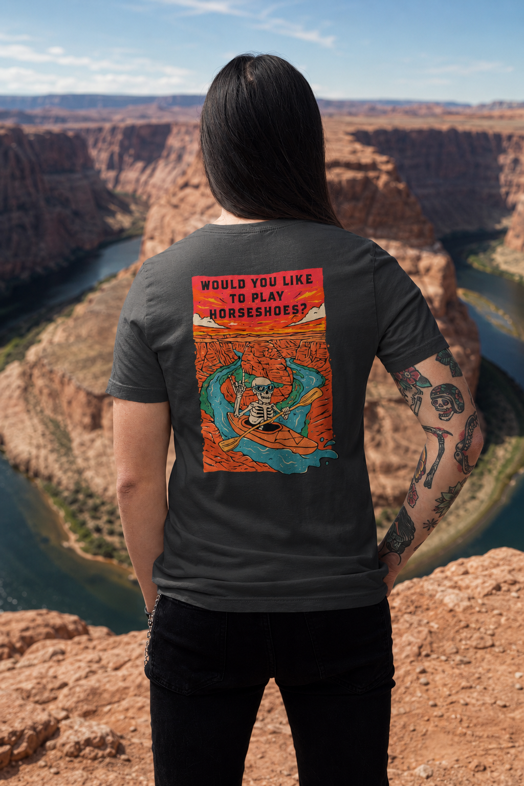 Woman wearing a Solid Asphalt Blend Do You Wanna Play Horseshoes? T-shirt with skeleton kayaker back graphic overlooking Horseshoe Bend