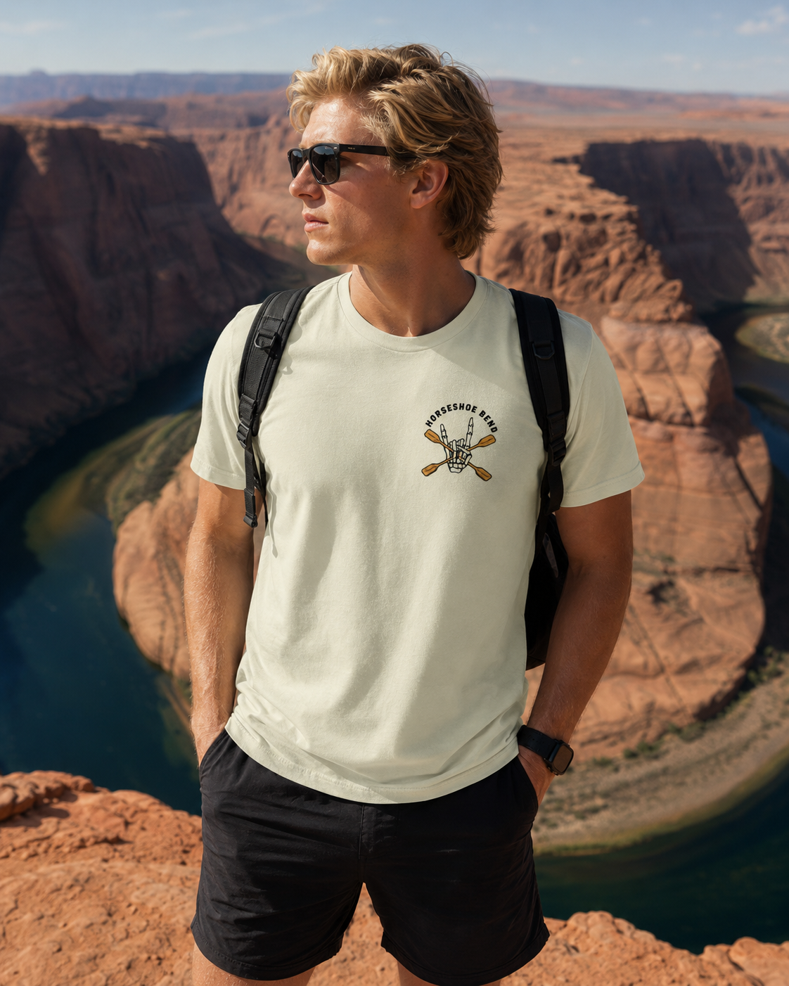 Man wearing a French vanilla Do You Wanna Play Horseshoes? T-shirt with small skeleton kayaker chest graphic overlooking Horseshoe Bend